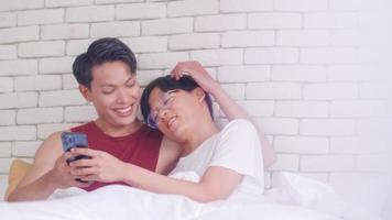 contento gay asiatico coppia la spesa tempo insieme nel letto a casa. foto