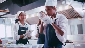 gruppo di studentesse avendo divertimento apprendimento per cucinare. femmina studenti nel un' cucinando classe. foto