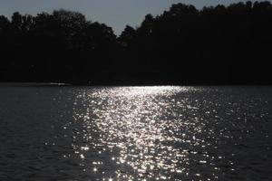 selettivo messa a fuoco di scintillante acqua con onda movimento riflettendo il luminosa luce del sole con un' molto morbido bokeh foto