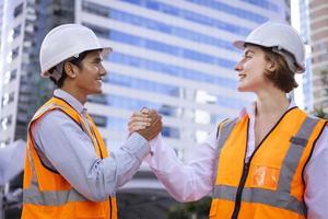 squadra di diversità ingegnere è avendo e stretta di mano dopo fatto ispezionando il costruzione progetto per moderno architettura e vero tenuta sviluppo mano al di sopra di concetto foto