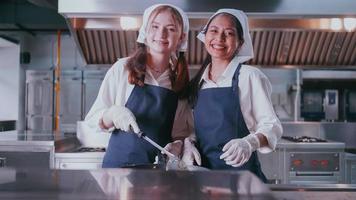 gruppo di studentesse avendo divertimento apprendimento per cucinare. femmina studenti nel un' cucinando classe. foto