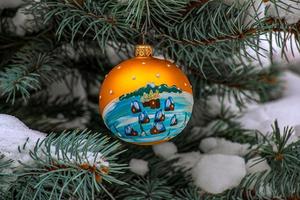 Natale palla sospeso su un' innevato ramo di un' Natale albero su un' festivo sfondo di bianca neve e nevoso bokeh con copia spazio. foto