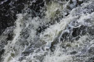 onde di acqua di il fiume e il mare incontrare ogni altro durante alto marea e Basso marea. in profondità blu tempestoso mare acqua superficie con bianca schiuma e onde modello, sfondo foto