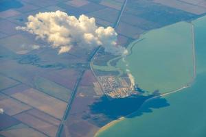 foto aerea di terreni agricoli. vista dall'aereo a terra. piazze di campi sotto le nuvole