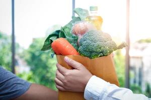 uomini consegnare drogheria, borse di cibo, frutta e verdure per clienti. cibo condivisione durante il coronavirus scoppio mangiare nutriente Alimenti per rafforzare il corpo e resistere patologia. foto