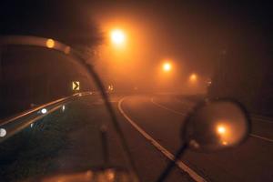 nebbia a notte strada e arancia alberi foto