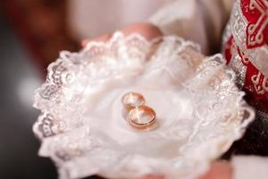 nozze cerimonia nel Chiesa. sacerdote Tenere piatto con elegante nozze anelli nel Chiesa per santo matrimonio. nozze anelli per sposa e sposo. alto qualità foto