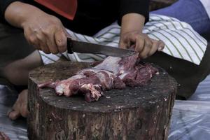 un' ritratto di I musulmani taglio carne su eid al adha di utilizzando taglio coltello foto