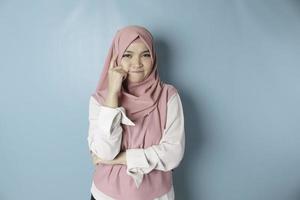 ritratto di un' riflessivo giovane musulmano donna indossare rosa hijab guardare a parte foto