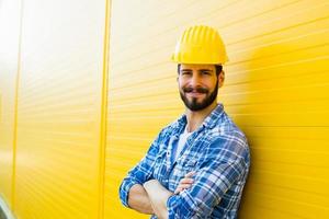 lavoratore adulto con casco sul muro giallo