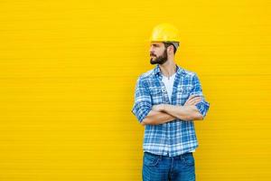 lavoratore adulto con casco sul muro giallo