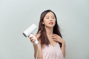 sorridente giovane donna cantando mentre asciugare foto