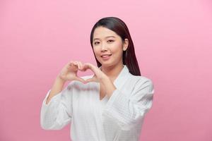 ritratto di giovane bellissimo asiatico donna mani gesto nel cuore forma foto