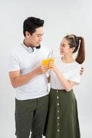 un' salutare giovane asiatico coppia potabile arancia succo foto