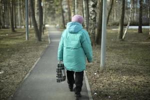 donna nel Russia passeggiate giù strada. pensionato nel città. ragazza a partire dal Indietro. foto