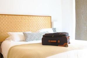 valigia sul letto all'interno di una stanza d'albergo foto