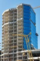 il processi di vetri un' nuovo grattacielo nel un' moderno Residenziale edificio utilizzando un' verricello e sospeso piattaforme. foto