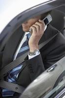 uomo d'affari utilizzando il telefono cellulare in auto foto