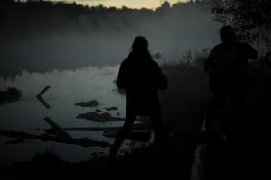 uomo nel nebbia prima alba. riposo su lago. foto