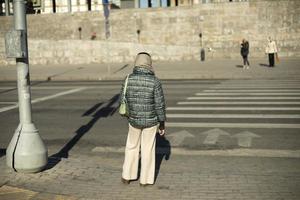 ragazza è in attesa su strada. pedone attraversamento nel città. foto