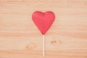 cuore di cioccolato rosso su fondo di legno foto