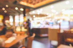 l'interno del ristorante con il cliente e il tavolo in legno sfocano lo sfondo astratto con luce bokeh foto