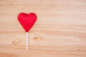 cuore di cioccolato rosso su fondo di legno foto