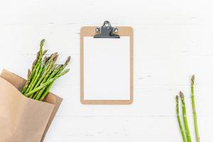 asparagi verdi freschi con mockup di appunti di carta foto