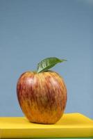 Mela frutta su superiore di un' libro pila, su il indietro di scuola classi. foto