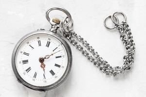 Vintage ▾ tasca orologio con catena su bianca gesso foto