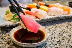 primo piano sushi sashimi con bacchette e salsa di soia foto