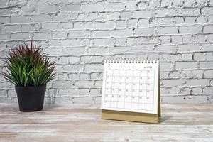 luglio 2022 bianca calendario con in vaso pianta su di legno scrivania. foto