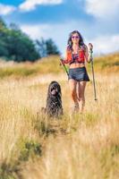 ragazza con sua cane su un' nordico a piedi viaggio foto