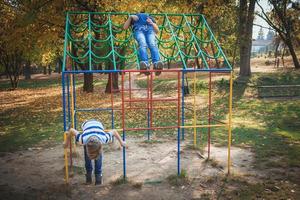 Due ragazzi avendo divertimento su il terreno di gioco a il parco. foto