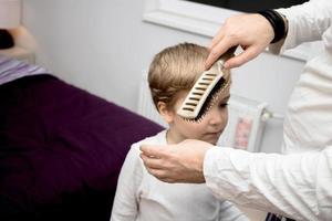 irriconoscibile padre spazzolatura figli maschi capelli. foto