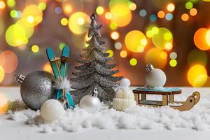 astratto Avvento Natale sfondo. inverno decorazioni ornamenti giocattoli e palle su sfondo con neve e sfocato ghirlanda luci. allegro Natale tempo concetto. foto