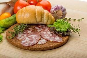 salame su di legno tavola e di legno sfondo foto