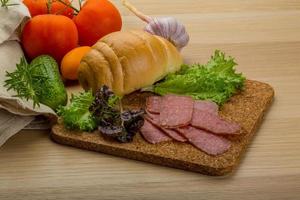 salame salsicce su di legno tavola e di legno sfondo foto