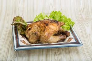 arrostito pollo su il piatto e di legno sfondo foto