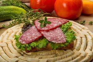 salame salsicce su di legno tavola e di legno sfondo foto