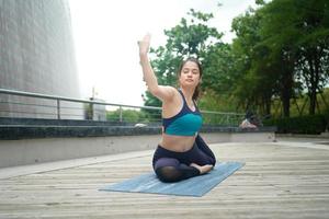 giovane attraente donna fare allungamento yoga esercizio nel il parco. foto