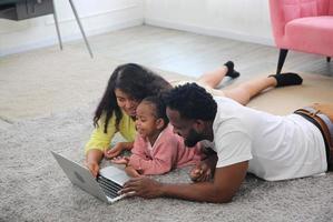 contento africano famiglia avendo giocoso tempo a casa, famiglia amore, genitori e bambino piccolo interno foto