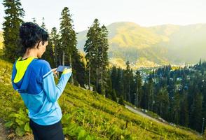 femmina persone mani hold smartphone nel panoramico Posizione su vacanze. smartphone fotografia all'aperto foto