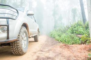 ruota camion avvicinamento nel campagna paesaggio con fangoso strada. estremo avventura guida 4x4 veicoli per trasporto o viaggio o fuori strada gare nel all'aperto natura. 4wd pneumatico automobile su sporco montagna. foto