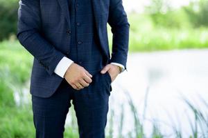 un' uomo nel un' elegante completo da uomo contro il sfondo di natura. foto