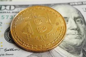 bitcoin dorato su banconote in dollari statunitensi soldi per affari e commerciali, valuta digitale, criptovaluta virtuale, tecnologia blockchain. foto