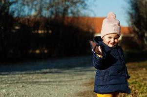 piccola bambina nella giornata di sole tenere il cellulare in mano. foto