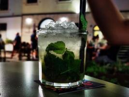 un' bicchiere di Mojito con suo condimenti su un' caffè tavolo foto