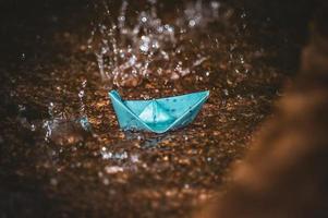 origami carta barca nel il pioggia foto