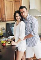 contento giovane coppia avere divertimento nel moderno cucina foto